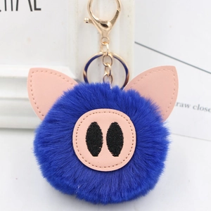 Detail of cute navy blue faux fur pig keychain with pink leather ears and gold metal clasp