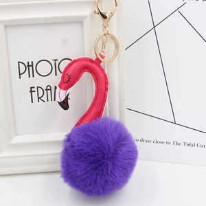 Detail of pink plush flamingo keychain with gold alloy ring and faux fur texture