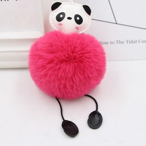 Close-up of fluffy panda keychain with pink pom-pom and black and white leather details