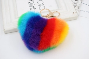 Detail of a fluffy rainbow heart keychain with soft plush texture and golden metal clasp