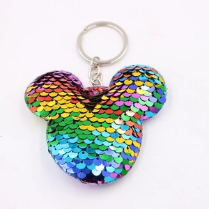 Dettaglio macro del portachiavi Mickey con paillettes e texture a scaglie di pesce arcobaleno