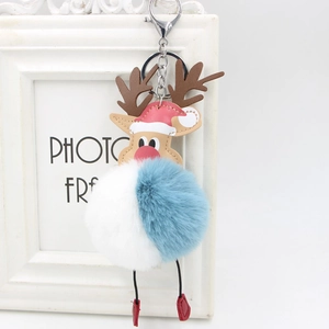 Detail of reindeer plush pompom keychain with red hat and blue white faux fur ball