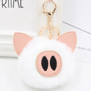 Close-up of white plush pig keychain with pink leather ears and gold metal clasp