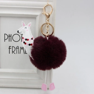 Dettaglio macro del portachiavi alpaca di peluche con pelliccia bordeaux e chiusura dorata