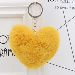 Detailed close-up of fluffy yellow heart plush keychain with silver metallic ring