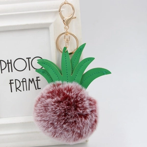 Burgundy pom-pom pineapple keychain with green faux leather leaves and golden clasp