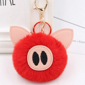 Detailed close-up of a red plush pig keychain with soft fur and gold metal hardware