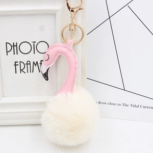 Detail of pink flamingo plush keychain with white faux fur pom-pom and gold metal clasp