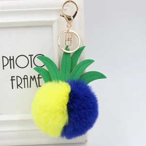 Detail of pineapple faux fur pompom keychain with green PU leaves and golden lobster clasp