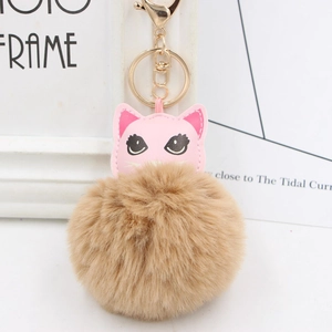 Détail de porte-clés chat en cuir rose avec pompon doux et anneau doré brillant