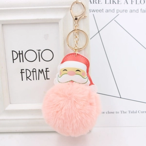 Close-up of golden metal clasp and fluffy pink pom pom on Santa Claus keychain