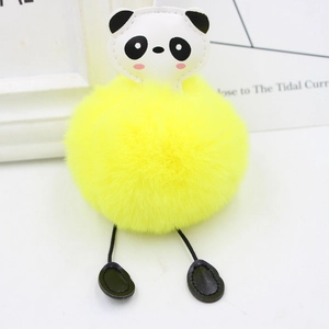 Detail of cute panda plush keychain with bright yellow fluffy faux fur ball on bags