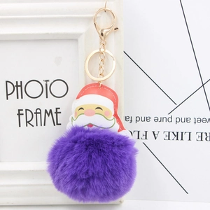 Detail of purple faux fur pompom keychain with Santa Claus charm and gold lobster clasp