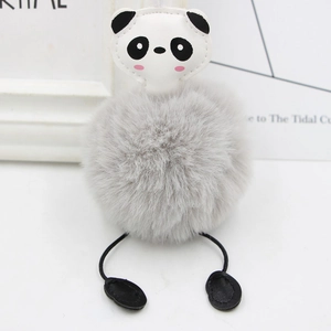 Detail of cute panda plush keychain with grey faux fur pom pom and leather paw charms