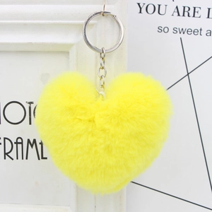 Vibrant yellow heart plush keychain with silver keyring hanging in a stylish setting