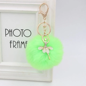 Detail of neon green faux fur ball keychain with rhinestone ballerina and gold lobster clasp