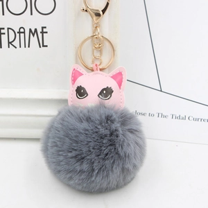 Tête de chat en cuir rose avec pompon en fausse fourrure grise et porte-clés doré
