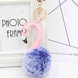Detailed view of plush flamingo keychain with purple faux fur pompom and golden clasp