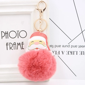 Close-up of pink faux fur pompom keychain with Santa Claus PU leather charm and gold clasp