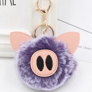 Detail of cute purple plush pig keychain with soft faux fur and pink PU leather snout