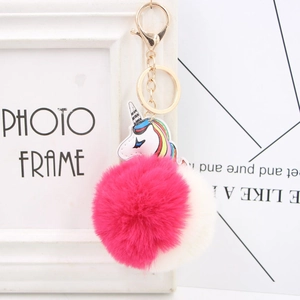 Detail of colorful unicorn pompom keychain with golden clasp and soft faux fur pom