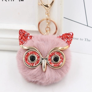 Detail of pink faux fur owl keychain with glitter accents and gold metal clip