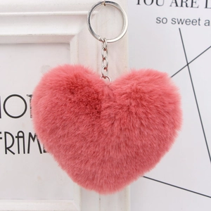 Close-up of a pink plush heart keychain with soft faux fur texture and silver metal ring