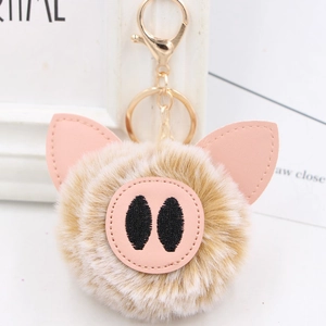 Close-up of fluffy pig nose keychain with pink leather detail and golden lobster clasp