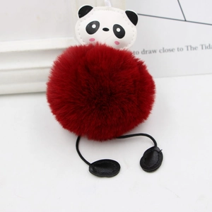 Detail of cute panda plush keychain with large dark red faux fur pompom and PU leather face