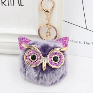 Detail of owl plush keychain with purple sequins and a gold metal lobster clasp