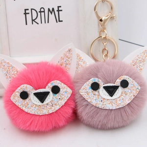 Sparkly fox fur pom pom keychain in rose red and pink colors with gold hardware