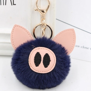 Close-up of cute blue plush pig keychain with pink leather ears and gold metal clasp