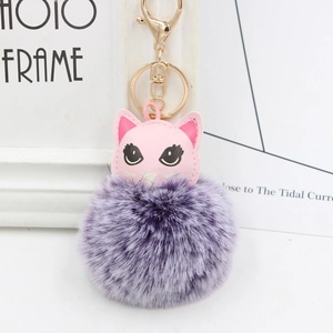 Détail d'un porte-clés chat en cuir rose avec pompon violet et fermoir doré chic