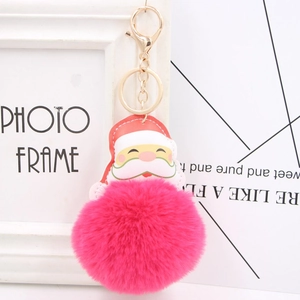 Detailed view of the fluffy magenta faux fur pom pom and festive Santa Claus keychain charm