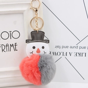 Détail d'un porte-clés bonhomme de neige avec pompon en fausse fourrure rouge et gris