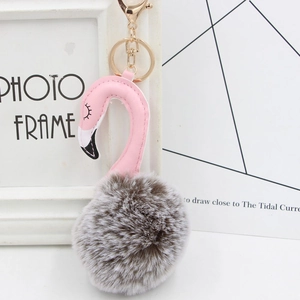 Detail of pink flamingo plush keychain with fluffy faux fur ball and gold metal clip