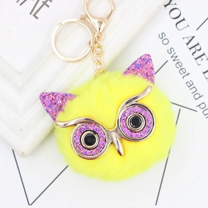 Sparkly yellow owl pompom keychain with purple sequins and gold eyeglass frames
