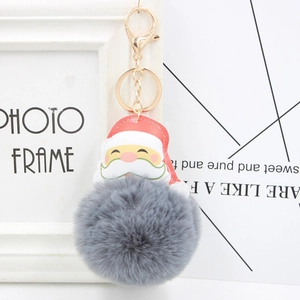 Detailed close-up of grey faux fur pom-pom Santa keychain with golden metal clasp