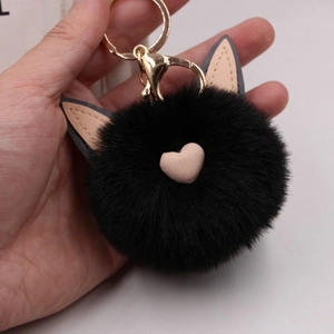 Vue détaillée d'un porte-clés cœur en peluche noire avec oreilles de chat et clip