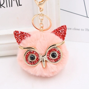 Close-up of pink faux fur owl keychain featuring red sequins and golden lobster clasp