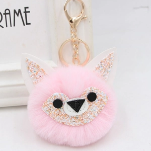 Close-up of pink fox plush keychain with colorful sequins and golden metal lobster clasp