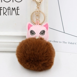 Détail d'un porte-clés chat en cuir rose avec pompon en peluche marron et clip doré