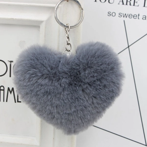 Detailed macro view of a fluffy gray heart-shaped plush keychain with a silver metal link