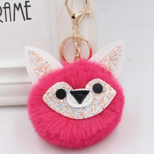 Detail of fuchsia faux fur fox keychain with sequins and golden metal clasp for bags