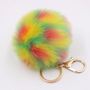 Detail of colorful faux fur keychain with multi-color plush ball and gold metal lobster clasp