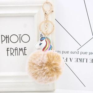 Detailed view of plush unicorn keychain with faux fur ball and rainbow leather accents