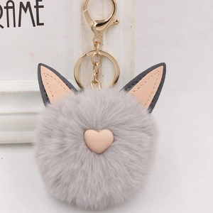Détail du porte-clés lapin en fausse fourrure grise avec cœur rose et fermoir doré