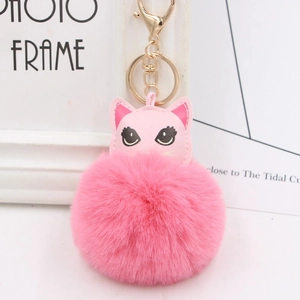 Gros plan détaillé du porte-clés pompon rose en fausse fourrure avec détails de chat