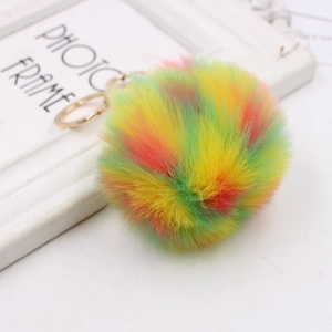 Detailed close-up of rainbow faux fur pom pom keychain with gold alloy metal ring