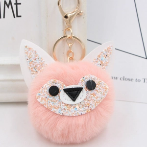 Close-up of pink fox pompom keychain featuring white ears and sparkling sequins